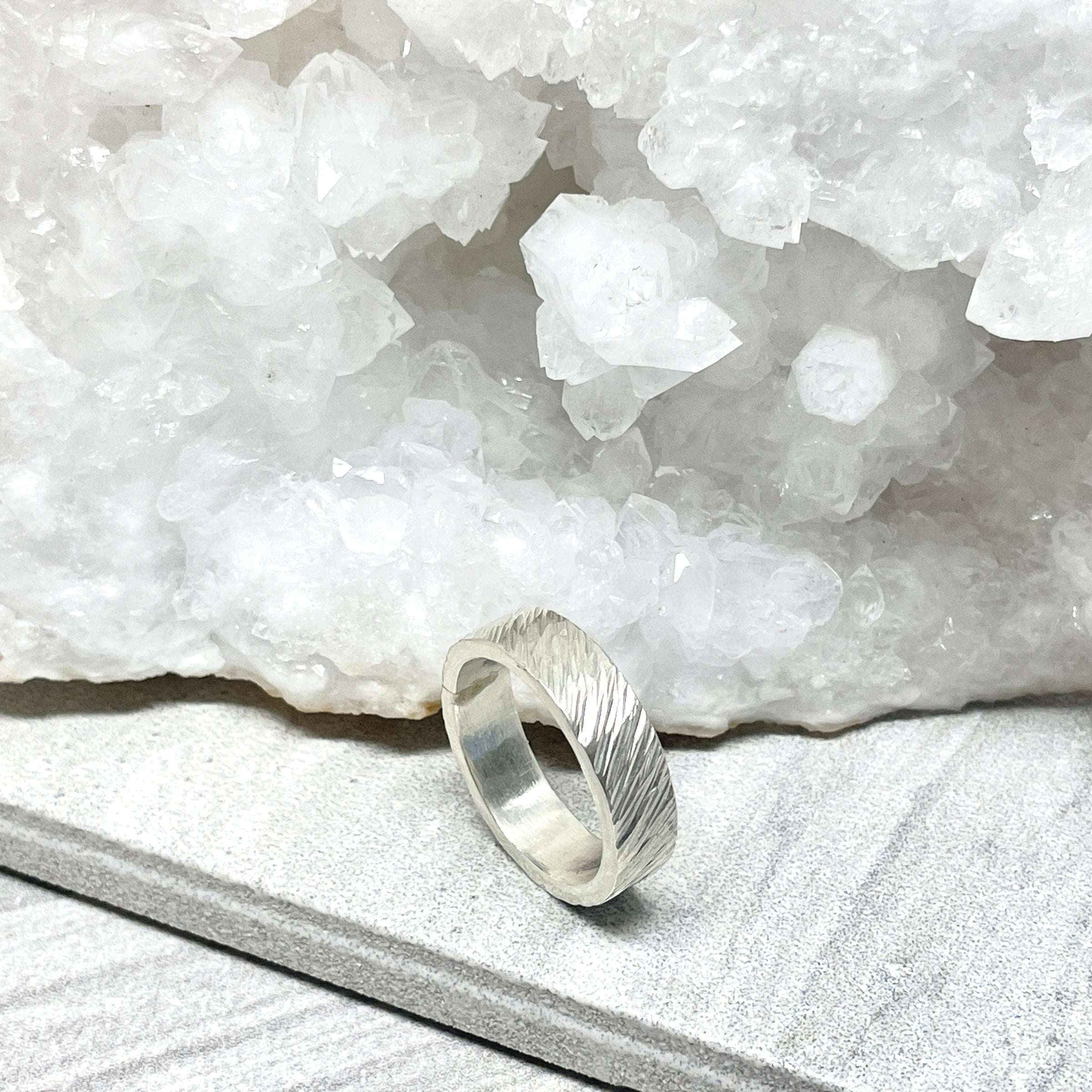 Silver ring on a white stone surface