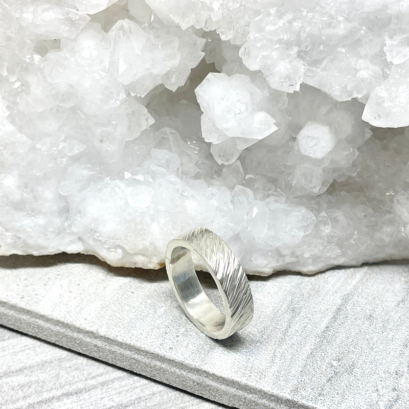 Silver ring on a white stone surface