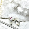 Two silver rings with embedded gemstones on a white crystal background
